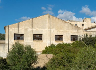 Facade of an old abandoned factory with broken glass. Island of Mallorca, Spain