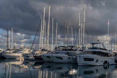 Palma de Mallorca, Spain; january 06 2023: Luxury yachts and sailboats moored in the harbor of the tourist city of Palma de Mallorca at sunset. Spain