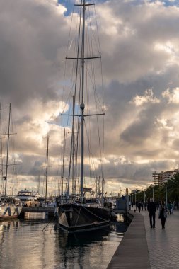 Palma de Mallorca, Spain; january 06 2023: Luxury yachts and sailboats moored in the harbor of the tourist city of Palma de Mallorca at sunset. Spain