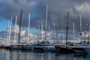 Palma de Mallorca, Spain; january 06 2023: Luxury yachts and sailboats moored in the harbor of the tourist city of Palma de Mallorca at sunset. Spain