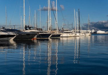 Palma de Mallorca, Spain; january 06 2023: Luxury yachts and sailboats moored in the harbor of the tourist city of Palma de Mallorca at sunset. Spain