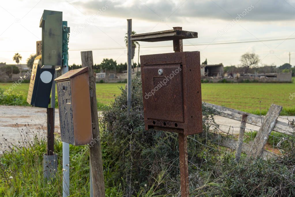 Primer plano de buzones viejos y deteriorados en una zona rural de la