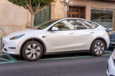 Felanitx, İspanya; 17 Mart 2023: Tesla şirketinin beyaz elektrikli arabası, elektrik şarj noktasında caddeye park edilmiş. Felanitx, Mallorca Adası, İspanya