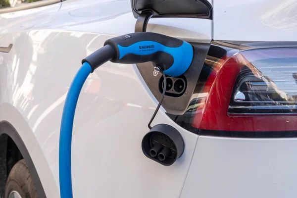 Felanitx, İspanya; 17 Mart 2023: Tesla şirketinin beyaz elektrikli arabası, elektrik şarj noktasında caddeye park edilmiş. Felanitx, Mallorca Adası, İspanya