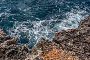 Akdeniz 'in dalgalı olduğu Mallorca adasının kayalık kıyıları. Portocolom, Mallorca Adası, İspanya