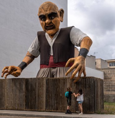 Manacor, İspanya; 30 Nisan 2023: Manacor Encantat şehir festivali halk hikayeleri veya Rondalles karakterlerinin caddelerinde büyük heykeller ile. Kolları açık bir dev heykeli. Manacor, İspanya