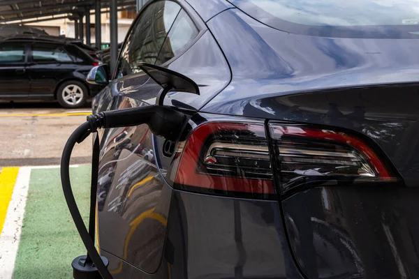 stock image Manacor, Spain; may 06 2023: Dark gray Tesla electric car, recharging at an urban electric charging point. Manacor, island of Mallorca, Spain