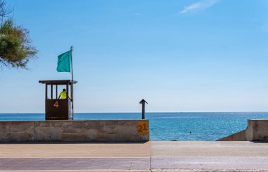 Yeşil bayrak sallayan bir sahil cankurtaran kulesinin genel görüntüsü. Mallorca Adası, İspanya