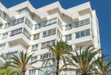 Palmiye ağaçları olan beyaz bir turist apartmanı. Mallorca Adası, İspanya