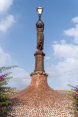 İspanya 'nın Manacor şehrinde bronz bir kadın heykeli bulunan sokak lambası.