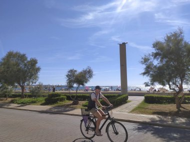 Palma de Mallorca, İspanya; 24 Eylül 2023: Palma de Mallorca plajı turistlerle birlikte sahilde gezinti ve yaz günü bisiklet. İspanya