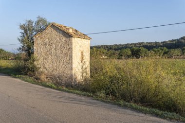 Gün doğumunda Mallorca adasının içinde terk edilmiş küçük bir kır evi. İspanya