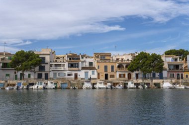 Portocolom, İspanya; Kasım 06 2023: Portocolom ve ünlü tekne iskelesinin manzarası, bir sonbahar günü gün doğumunda. Mallorca Adası, İspanya