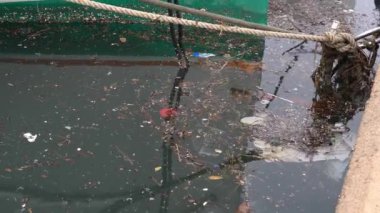 Yosun ve plastik enkaz içeren deniz suyuyla dolu bir tekne rıhtımına yakın çekim. Mallorca Adası, İspanya
