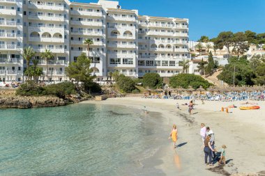 Cala Ferrera, İspanya; Mayıs 04 2024: Hamaklarla dolu ve otel kompleksleriyle çevrili ünlü Cala Ferrera plajının genel manzarası. Turist doygunluğunun görüntüsü. Mallorca Adası, İspanya