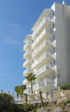 Güneşli bir sabahta Mallorcan tatil beldesi Cala d 'Or' daki beyaz bir otel kompleksinin dış görünüşü