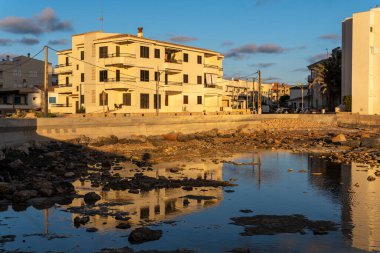 Büyük Colonia de Sant Jordi kasabasının kayalık kıyıları gün batımında, Balearic Adaları, İspanya