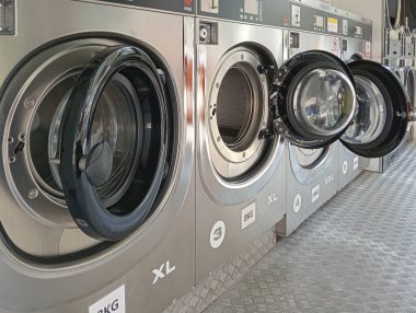 İspanya 'da ticari bir çamaşırhanede endüstriyel çamaşır makinesi ve kurutma makineleri.