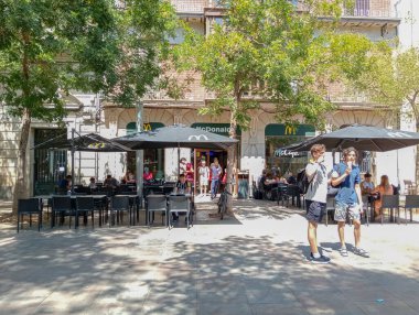 Palma de Mallorca, Spain; august 09 2024: Main facade of a fast food restaurant of the international restaurant chain McDonalds with customers. Palma de Mallorca, Spain clipart