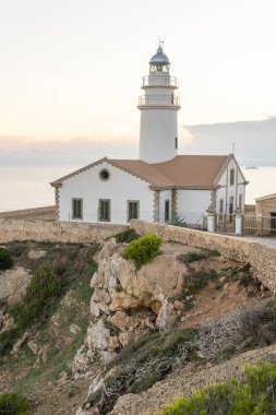 Mallorcan 'ın Cala Rajada kasabasının deniz feneri, Mallorca adasının kayalık kıyılarında, gün doğumunda. Balear Adaları, İspanya