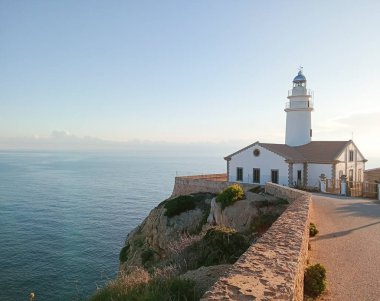 Mallorcan 'ın Cala Rajada kasabasının deniz feneri, Mallorca adasının kayalık kıyılarında, gün doğumunda. Balear Adaları, İspanya
