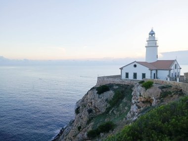 Mallorcan 'ın Cala Rajada kasabasının deniz feneri, Mallorca adasının kayalık kıyılarında, gün doğumunda. Balear Adaları, İspanya