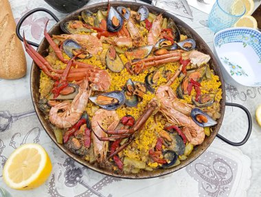 Masadaki paella tavasındaki deniz ürünleri paella 'sının yakın çekimi. İspanyol gastronomisinin resmi