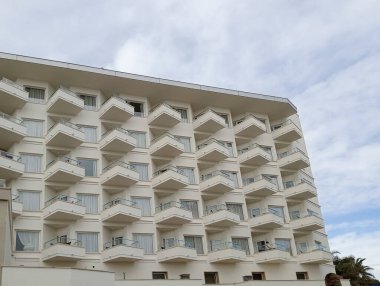 İspanya 'nın Palma de Mallorca plaj beldesinde balkonlarla dolu bir otelin ön cephesi.