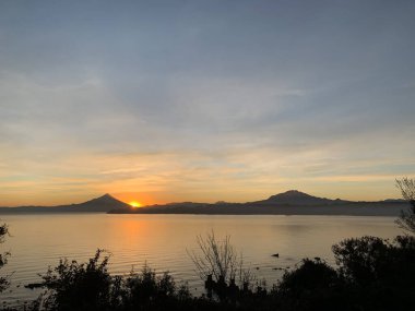 Sunrise over Llanquihue Lake in Puerto Varas with Osorno and Calbuco Volcanoes as backdrop. clipart