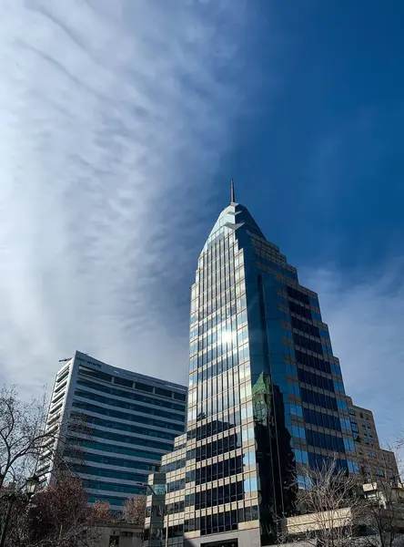 Santiago de Chile şehrinin gökdelenleri ve bulutlarla dağılmış mavi gökyüzü. Fotoğraf Las Condes Mahallesi 'nde çekildi..