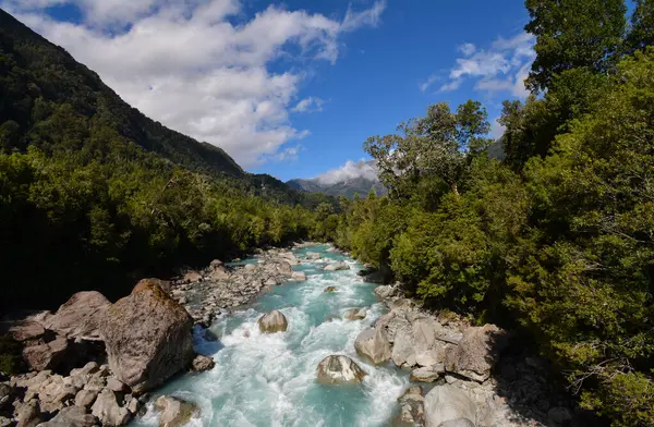 Şili 'nin güneyinde (Patagonya) büyük kayalar ve ormanlar bulunan turkuaz renkli nehir. Fotoğraf Hornopiren yakınlarında çekildi..