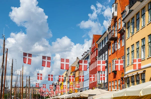 デンマークのコペンハーゲン ニャンハウスのカラフルな建物と観光通りの上にデンマークの旗を編む — ストック写真