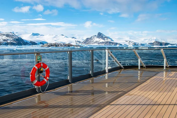 Cruise ship deck with railing in Antarctica. Snow mountain background. Winter cruise vacation concept.