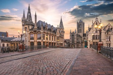 Gün batımında Gent şehrinde. Cobblestone Caddesi ve Belçika 'daki tarihi binalar.