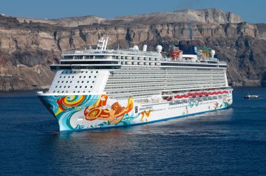 Thira, Greece - July 20, 2024: Norwegian Getaway Cruise Ship at Caldera Cliffs in Fira, Cruise Port Skala, Old harbor of Thira Santorini. clipart