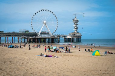 Lahey, Hollanda - 18 Ağustos 2024: Scheveningen, Lahey sahilindeki Ferris Wheel 'de turistler