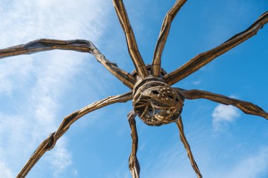 Bilbao, Spain - July 18, 2025: Low Angle View and Detail of Maman Spider Sculpture with Marble Eggs by Artist Louise Bourgeois Against Blue Sky in Bilbao