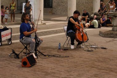 Ferrara, Italia - 26 Ağustos 2022: Ferrara Buskers Festivali sokak sanatına adanmıştır. VersaDuo, klasik POP dilinde repertuarı çerçeveleyen klasik ve popüler stillerin bir kombinasyonunu çalmaktadır..
