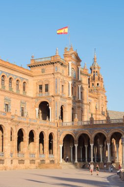Seville 'in ünlü Plaza de Espaa' sındaki ana binanın yan görüntüsü. İspanya 'da Sevilla Plaza de Espaa' da dalgalanan İspanyol bayrağı). 