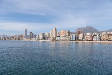 Landscape of the city of Benidorm in front of the Mediterranean coast. City with skyscrapers on the beachfront. View of the city of Benidorm from the sea. 