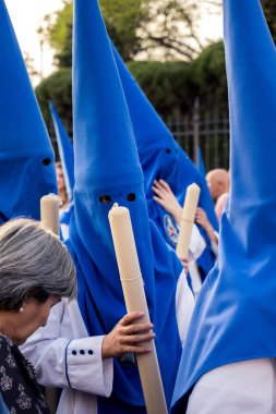 Nasıralı, Sevilla 'da kutsal hafta boyunca sunak mumuyla geçit töreni yapıyor. (Endülüs, İspanya).