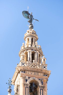 Giraldillo olarak bilinen kadın heykeli Sevilla Giralda 'sını taçlandırıyor. Sevilla Katedrali 'nin çan kulesinin tepesinde heykel ya da rüzgar gülü.