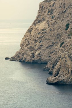 Deniz kenarındaki uçurum. Denize bakan bir dağın kayalık duvarı.