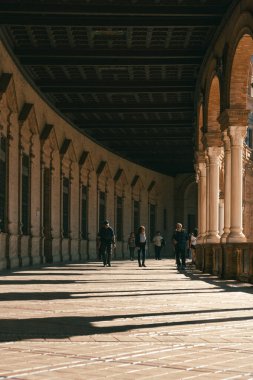 Seville, İspanya; 25 Ocak 2024: Sevilla Plaza de Espaa 'nın iç geçidinde gezinen turistler. Plaza de Espana Galerileri (İspanya Meydanı).