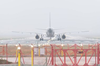 Seville; 6 Şubat 2024: Kalkış için kalkış izni bekleyen ticari bir Airbus uçağının arka görüntüsü. Uçak sisli koşullarda kalkışa hazırlanıyor..