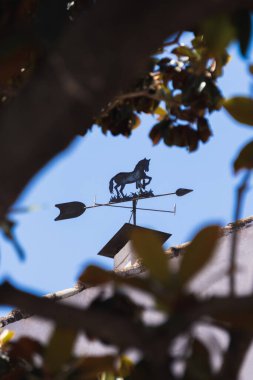 Jerez de la Frontera, İspanya; 19 Nisan 2024: Bir binanın çatısında at şeklinde dekoratif rüzgar gülü.