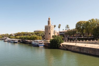 Seville, İspanya; 15 Haziran 2024: Sevilla 'daki Torre del Oro' nun önündeki Guadalquivir Nehri 'ne turist botları yanaştı.