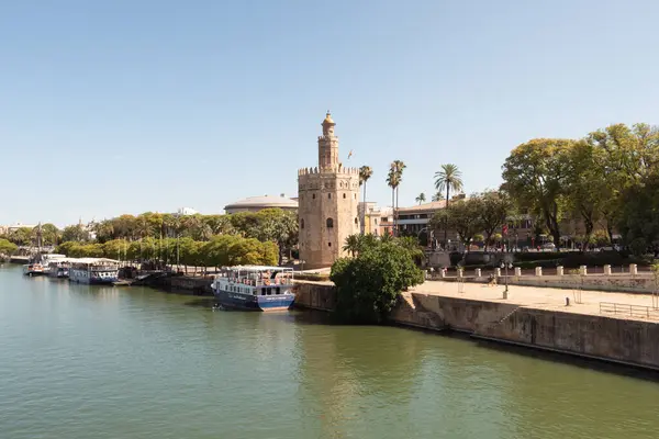 stock image Seville, Spain; June 15th 2024: Tourist boats docked on the Guadalquivir River in front of the Torre del Oro in Seville.