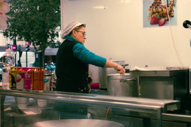 Murcia, İspanya; 27 Aralık 2024: Sokak yemekhanesinde aşçılık. Caddedeki churro standında aşçı..