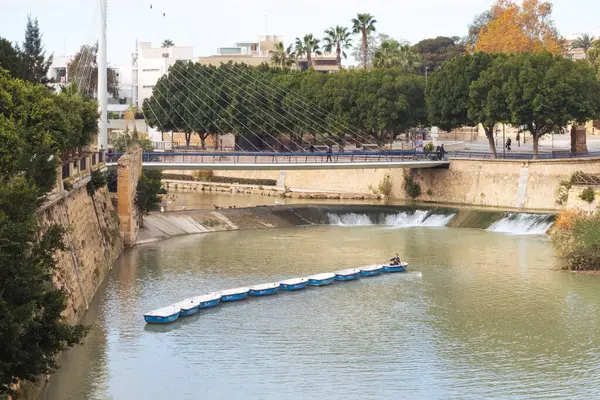 Murcia, İspanya; 27 Aralık 2024: Adam Murcia 'daki Segura Nehri' nde bir dizi küçük tekne taşıyor. Murcia 'da kiralık tekneler.